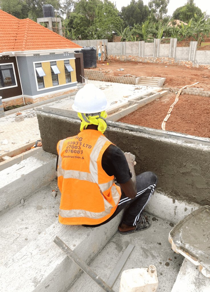 A professional engineer on a construction site in Kampala performing a slump test to verify the Concrete Grade C20 vs. C25 Standards for a new building.