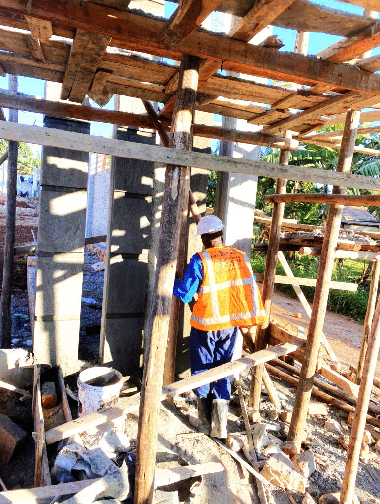 A structural engineer conducting a site inspection of reinforced concrete columns on a construction site in Kampala, Uganda